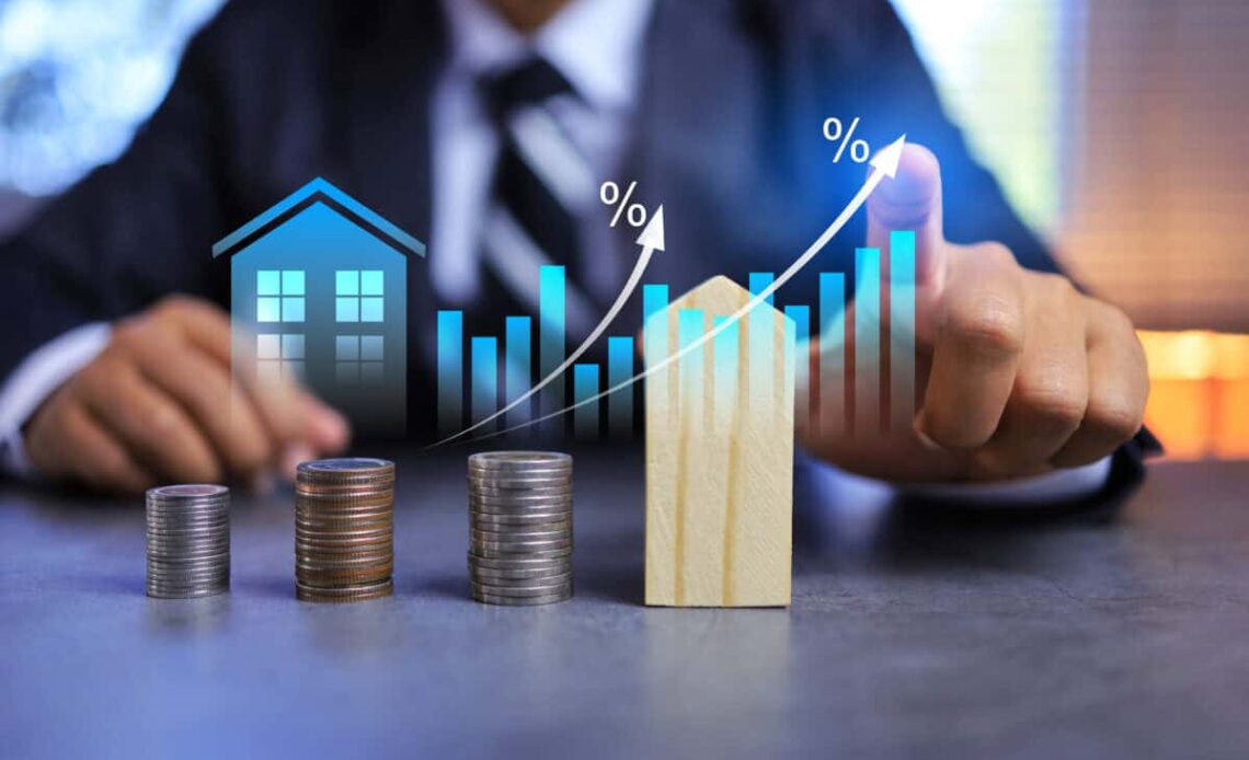 Real estate investment concept with person pointing on growth graph and coin stacking to get profit from property