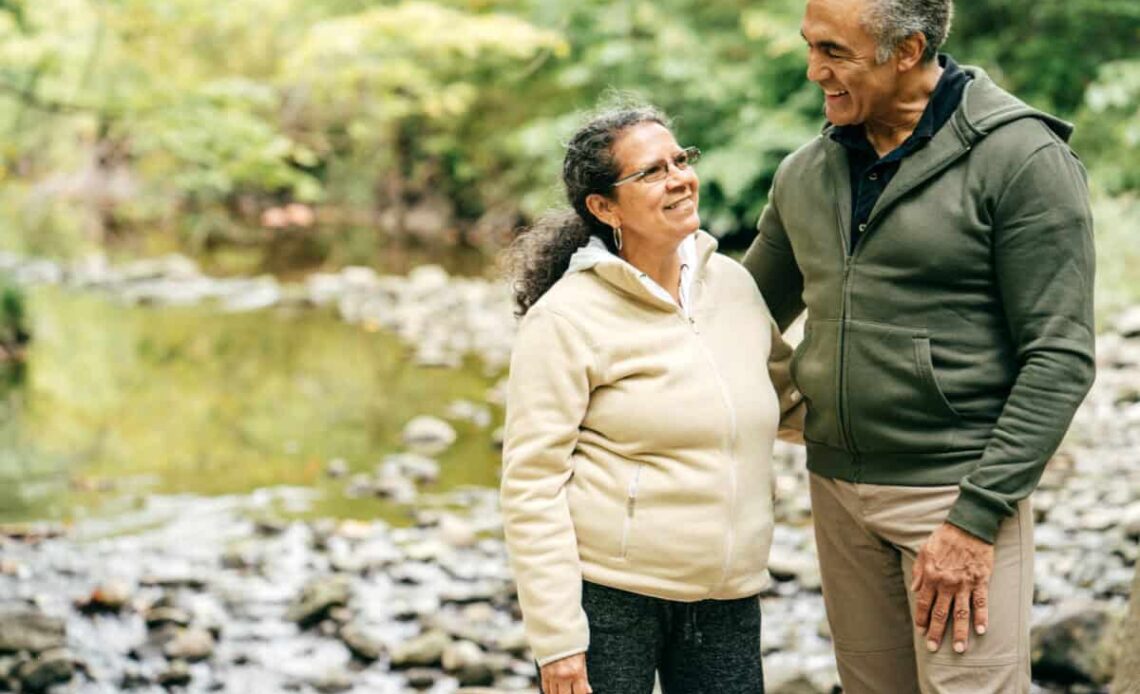Two seniors walk in the forest
