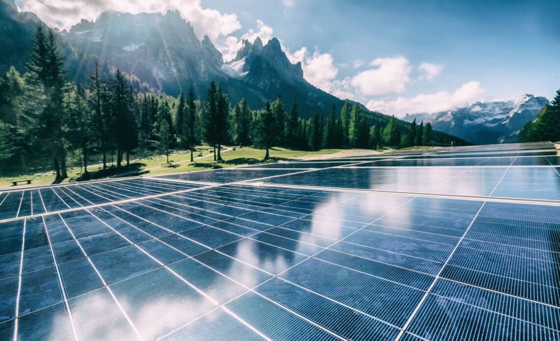 A solar cell panel generates power in a country mountain landscape.