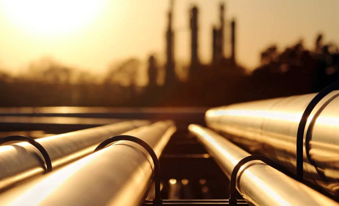 golden sunset in crude oil refinery with pipeline system