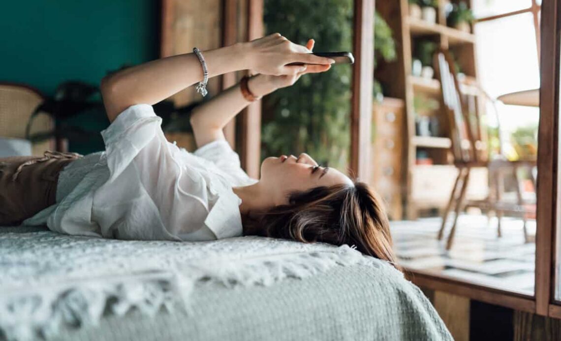 woman relaxes with phone